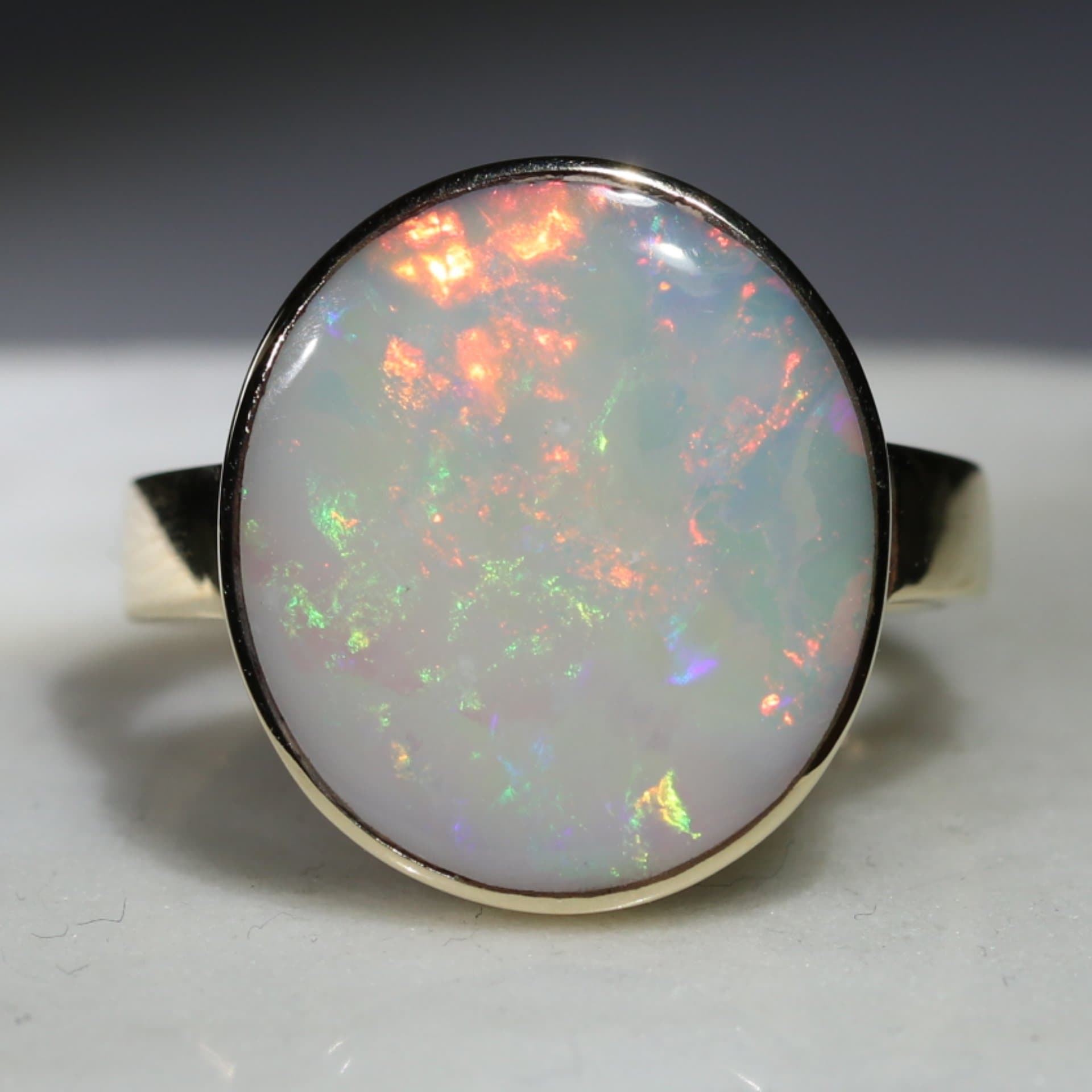 Large White Opal with Bright Flashes of Yellow, Green and Red Gold Rin